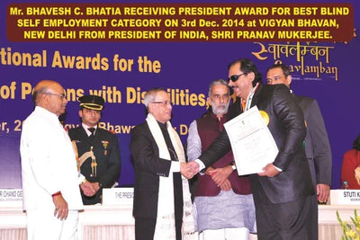 Man receiving award at ceremony for self-employment for the blind, shaking hands on stage.