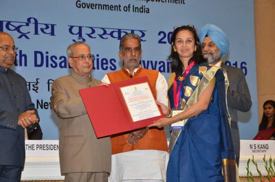 Woman receiving award from dignitaries at official ceremony, Vigyan Bhawan, New Delhi